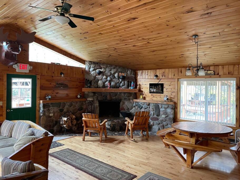 BrimleyBrimley Lodge / Sleeps 36 / Snowmobile & ORV Trail的客厅设有壁炉、桌子和椅子