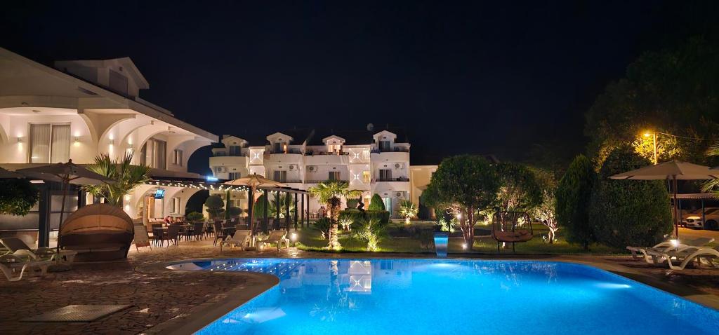 东吉托伊Hotel Comfort & Villas的一座游泳池,在晚上在建筑物前