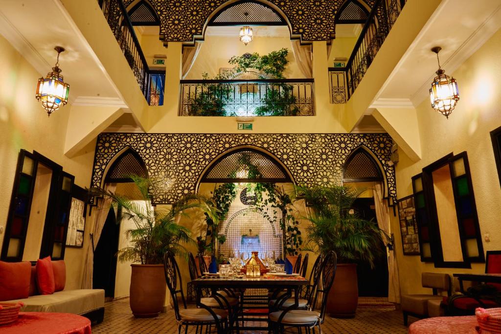 马拉喀什Riad Dar La Rose的大楼内的餐厅,配有桌椅