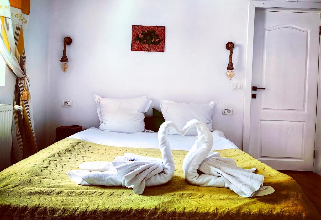 西蒙Voinescu House - Natural Living & Eating的床上有两条毛巾天鹅,心中