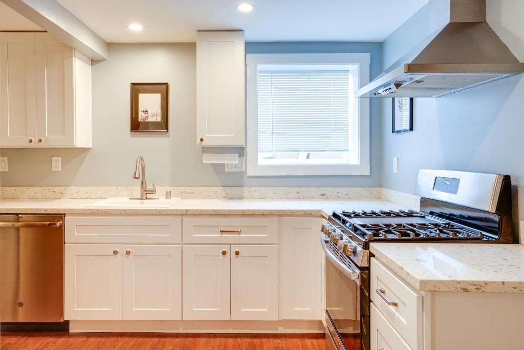 奥克兰Bikeable Apartment - 2 Mi to Downtown Oakland!的厨房配有白色橱柜和炉灶烤箱。