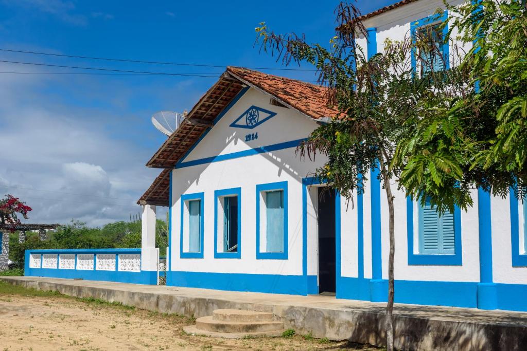 São João do CaririFazenda Poço das Pedras的蓝白色的建筑,前面有树