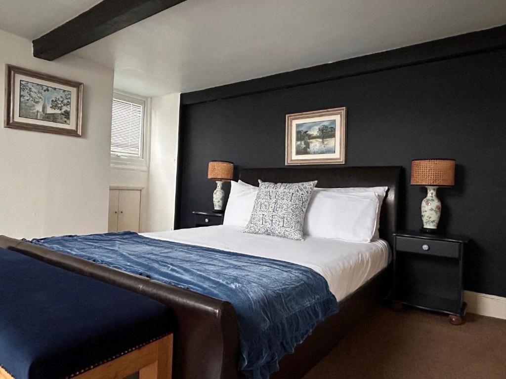 埃姆斯伯里费尔劳恩别墅酒店的一间卧室配有一张带蓝色毯子的大床