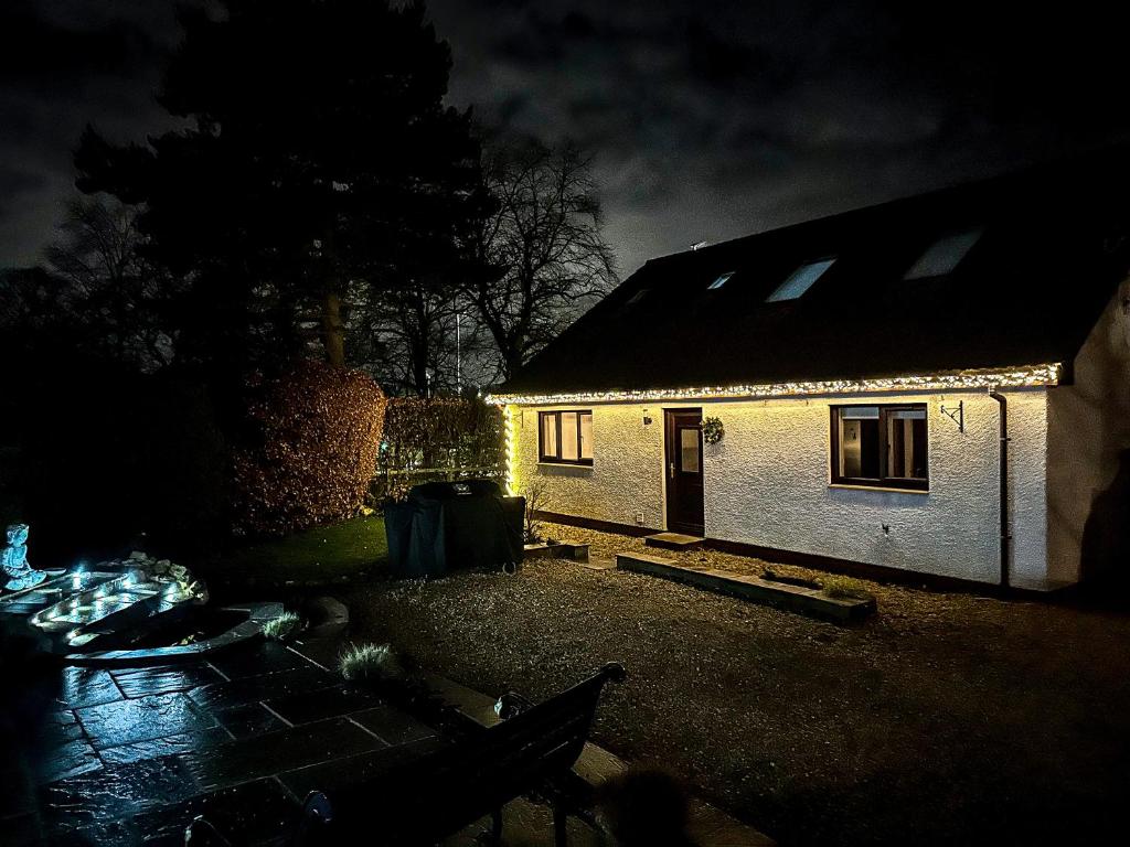 柯金蒂洛赫Woodhead view的一间白色的小房子,晚上有灯