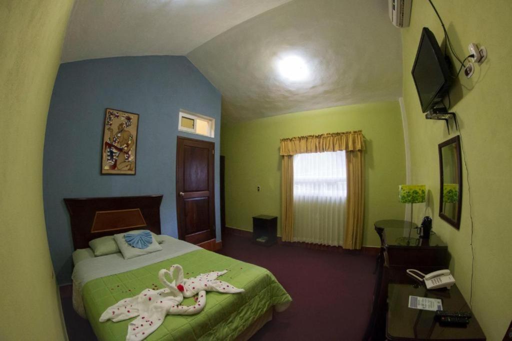 弗洛勒斯Ribiera del Lago Peten Itza的一间卧室配有一张床、一张桌子和一部电话