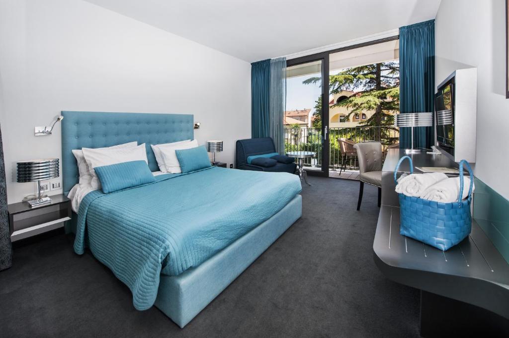 罗维尼阿鲁宾努酒店的一间卧室设有蓝色的床和一个阳台