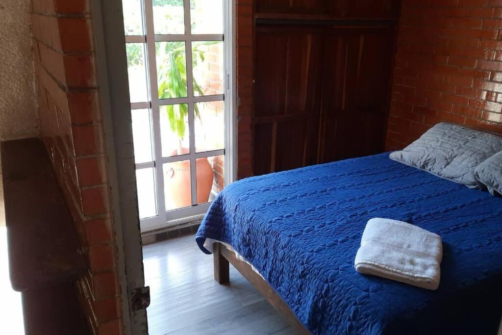 圣克鲁斯华特库Loft guelaguetza A的一间卧室配有一张带蓝色毯子的床和窗户。