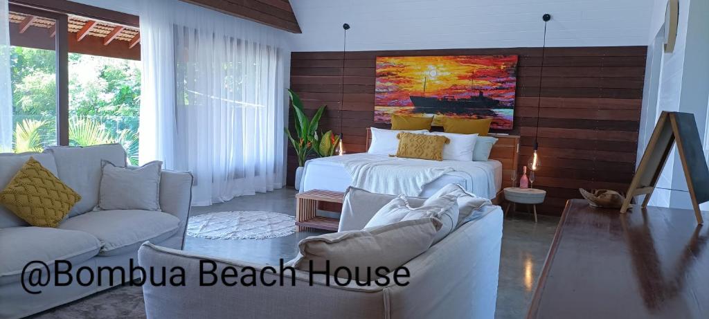 卢甘维尔Bombua Beach House的一间带两张床和一张沙发的客厅