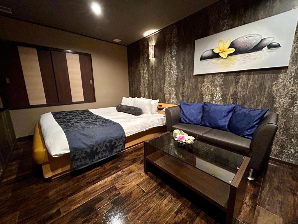 东京Hotel Asian Color (Adult Only)的酒店客房,配有床和沙发