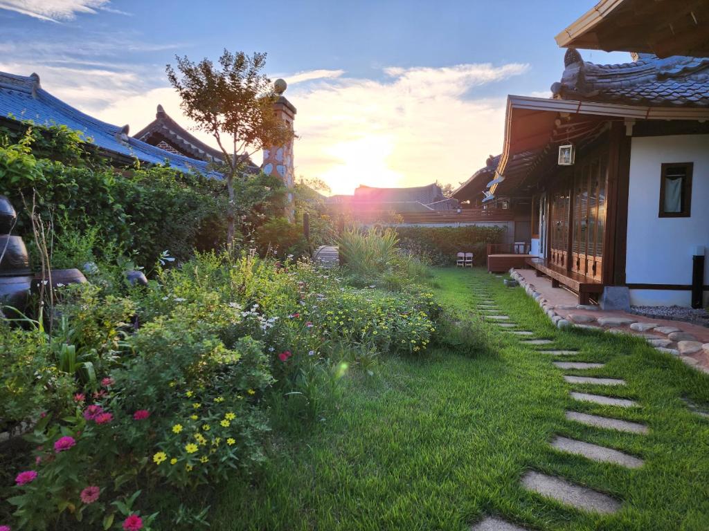 全州市Jahayeon Hanokstay的庭院里种着小径和鲜花的花园