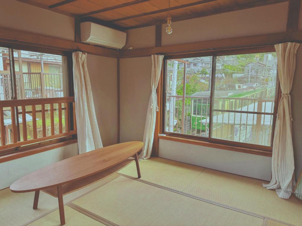 镰仓市江ノ電の線路沿いにある宿【film koshigoe】的两间窗户前设有木凳的房间