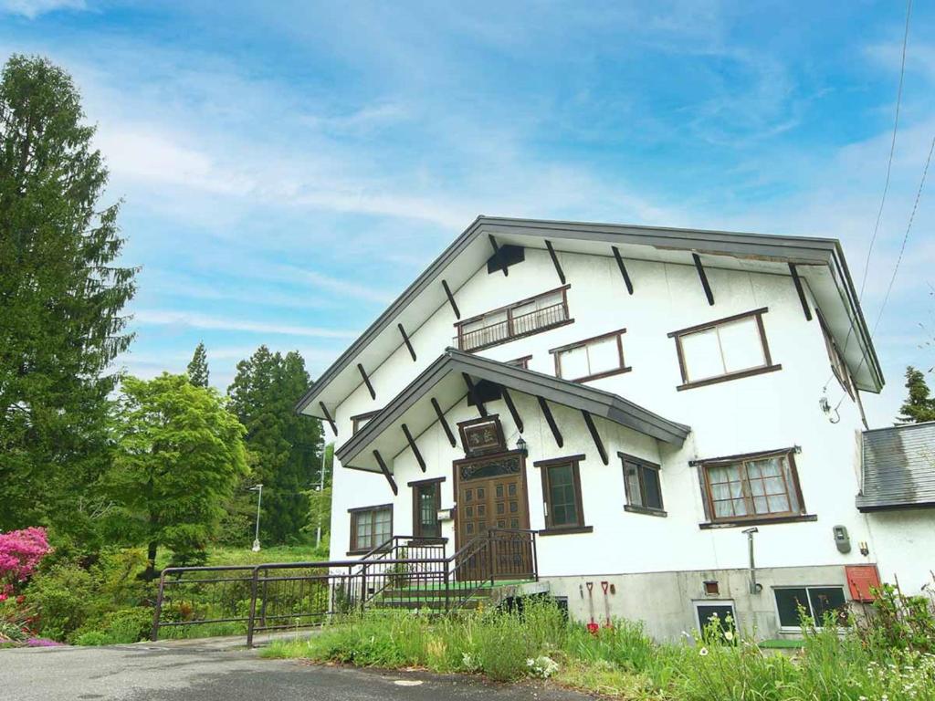 Chikuniロッヂ秀岳的白色房子的一侧设有窗户