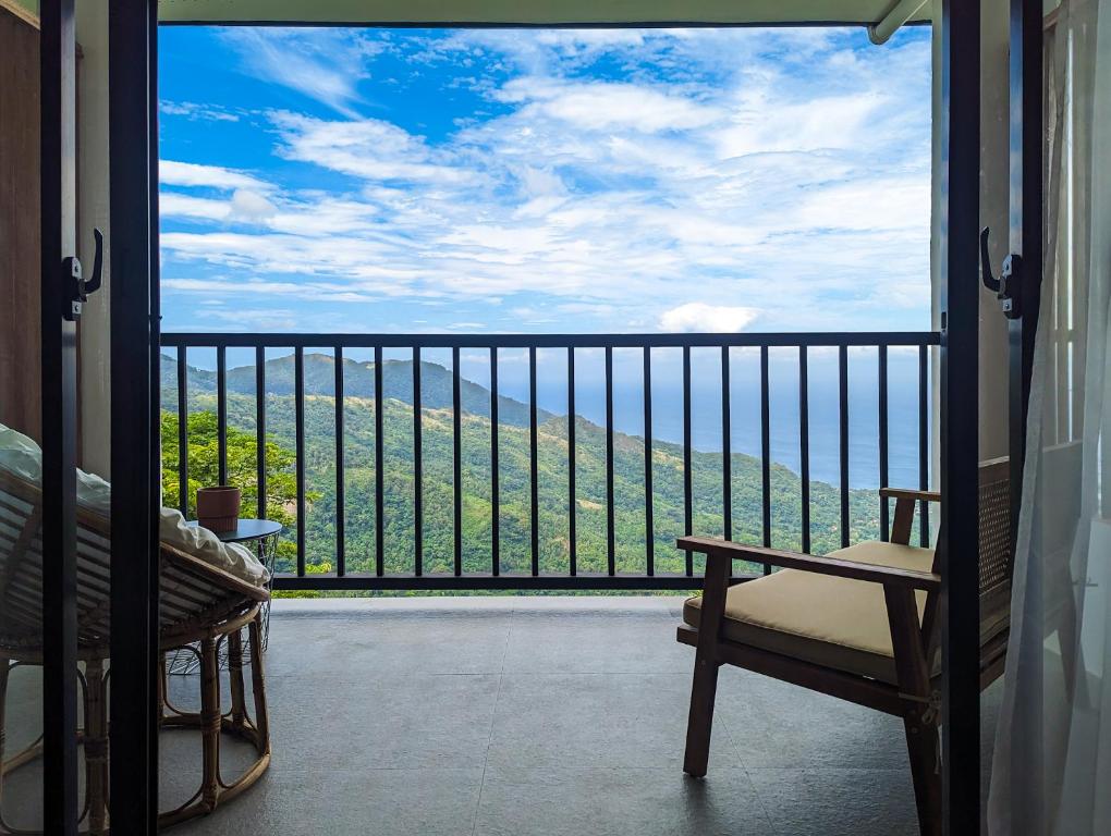 波尔多·格尼拉Ponderosa Golf and Country Club的客房设有带椅子的阳台,享有美景。