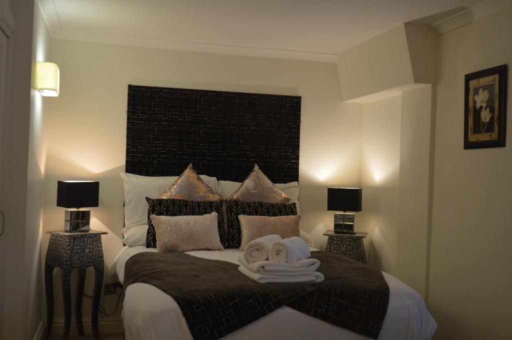 博克斯本森之家博克斯酒店的一间卧室配有一张大床和毛巾