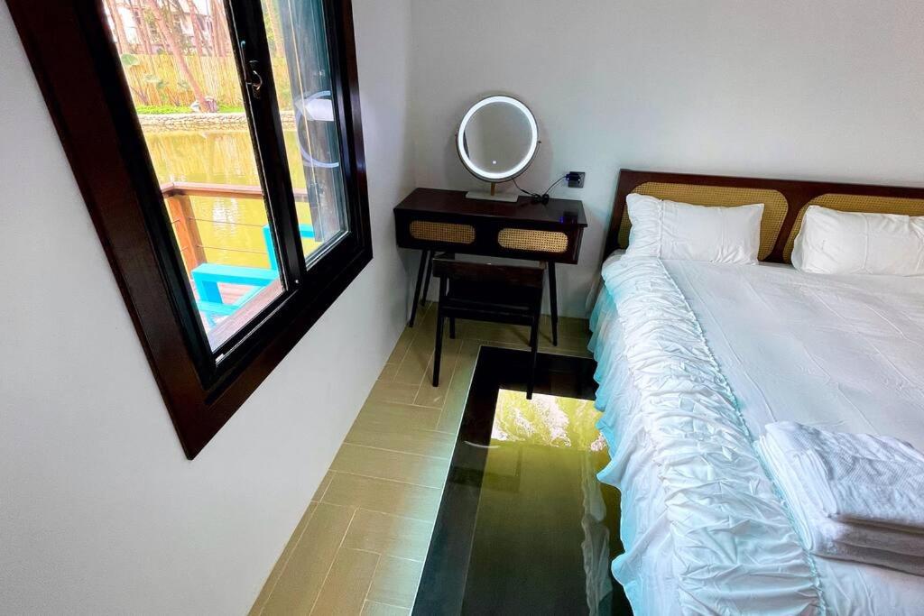 琅勃拉邦Wooden House on lake,city center的卧室配有一张床和一面镜子,靠窗