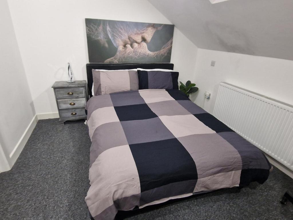 伦敦Confystay的卧室配有一张床,墙上挂有绘画作品