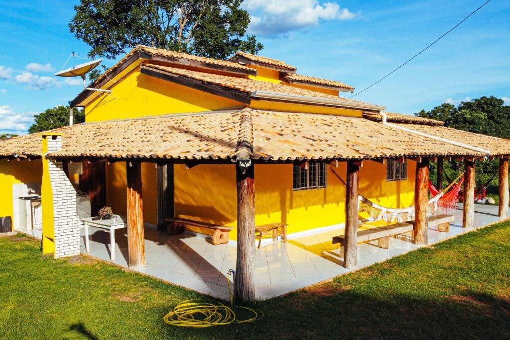 诺布里斯Casa Flor da Serra的一座带茅草屋顶的大型黄色房屋