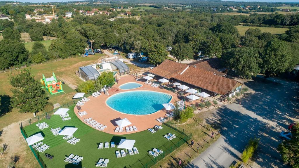 罗卡马杜尔Camping les Cigales Rocamadour的享有带游泳池的度假村的空中景致