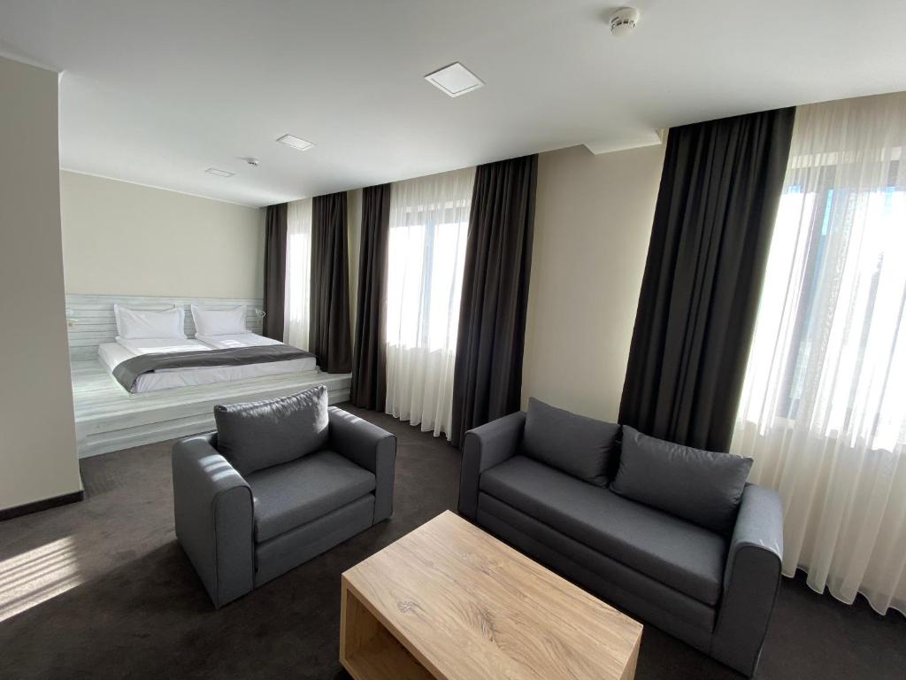 鲁塞Комплекс Дунав的一间卧室配有一张床、一张沙发和一把椅子
