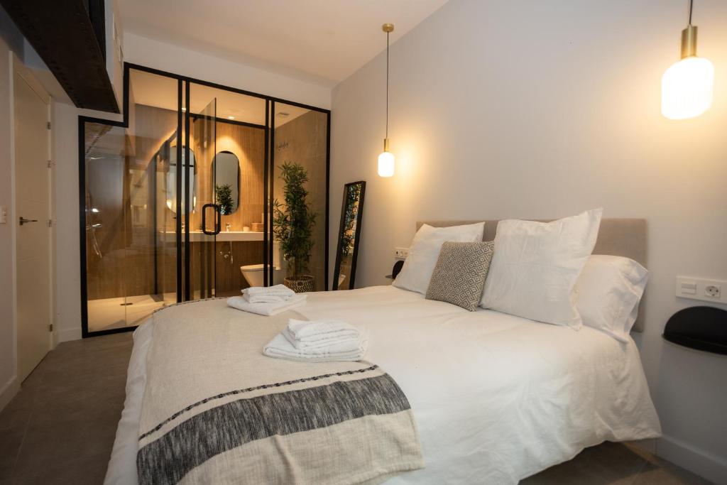 马拉加Diana Suites 23的卧室配有带毛巾的大型白色床