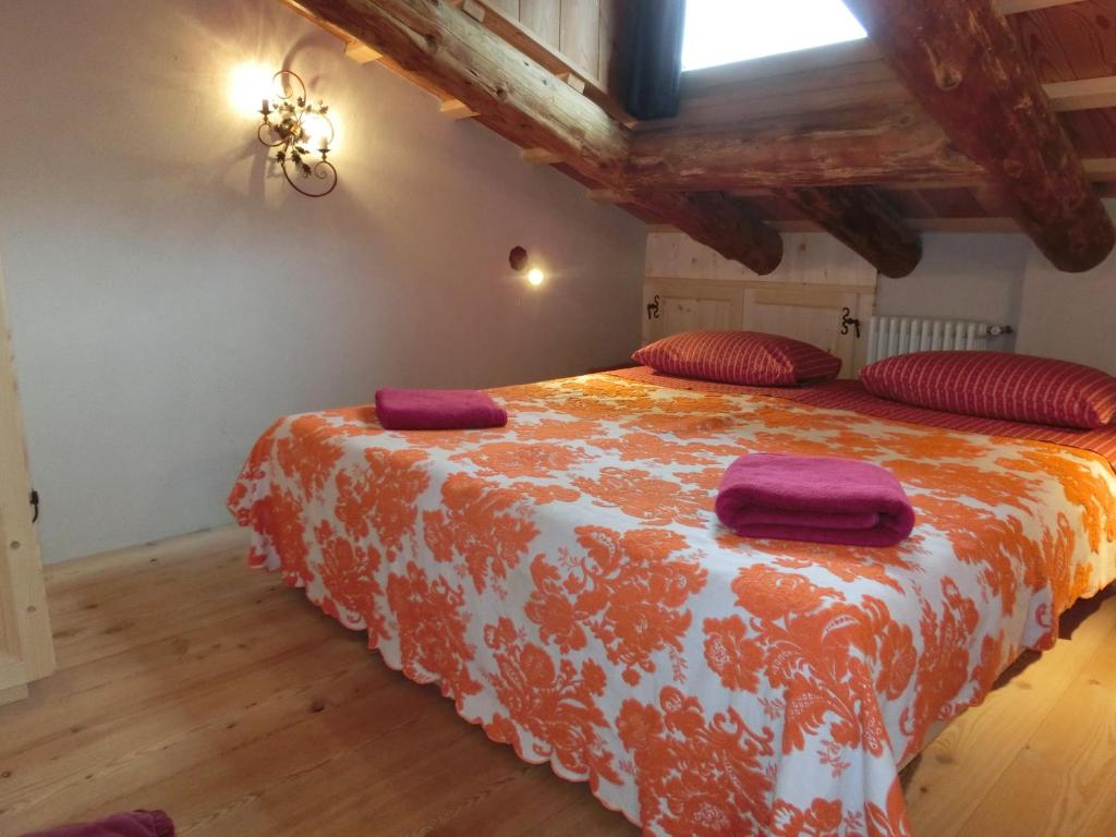 科尔蒂纳丹佩佐CORTINA LODGE的一间卧室配有一张带红色枕头的大床