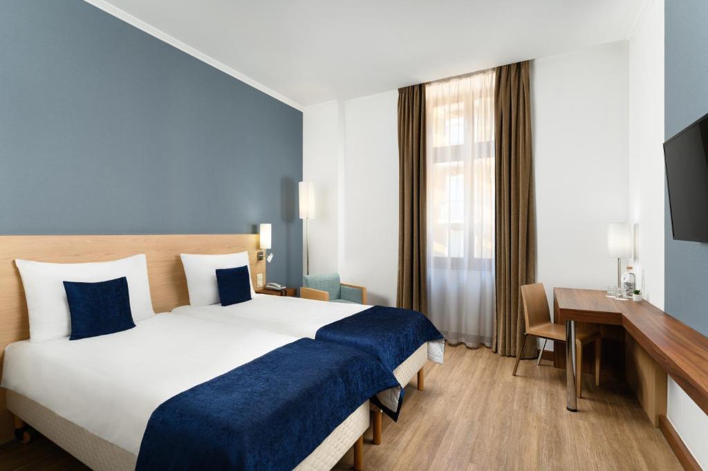 布达佩斯Hotel Bristol Budapest的酒店客房设有一张大床和一张书桌。
