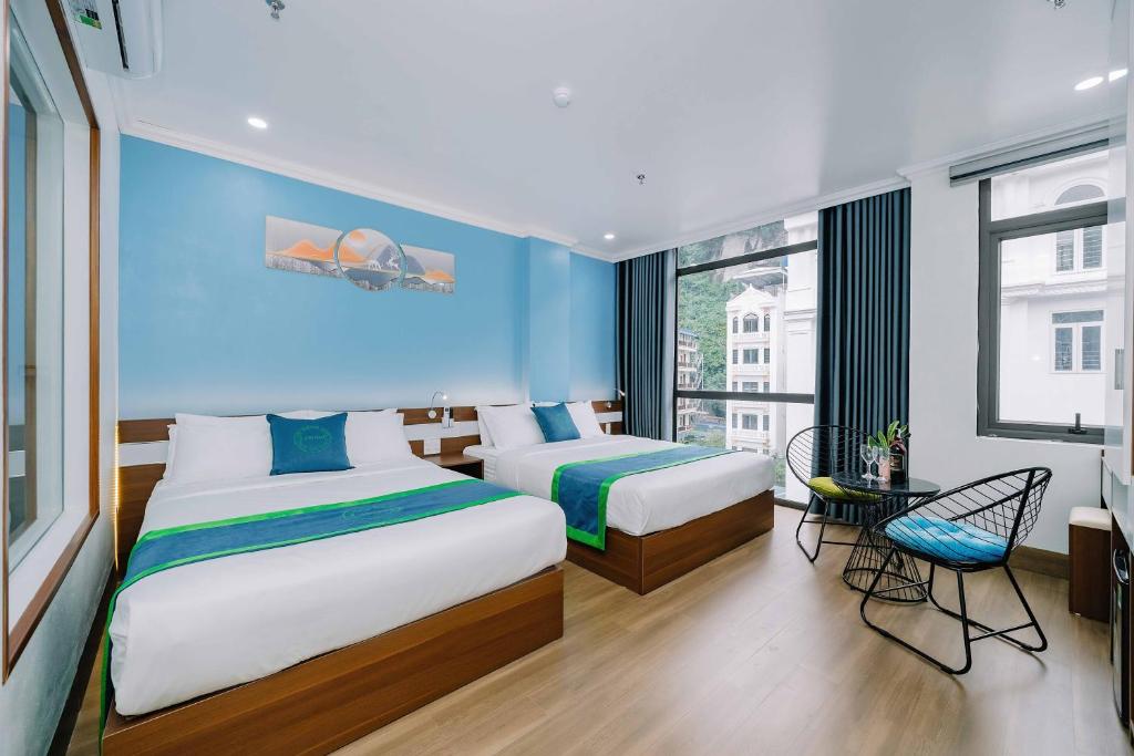吉婆岛TOMMY HOTEL的一间卧室设有两张床和蓝色的墙壁