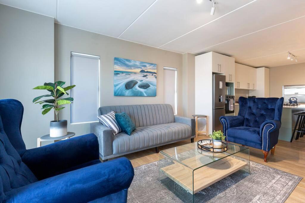 兰格班Nivica 56 Luxury Apartment Langebaan的客厅配有沙发和2把蓝色椅子