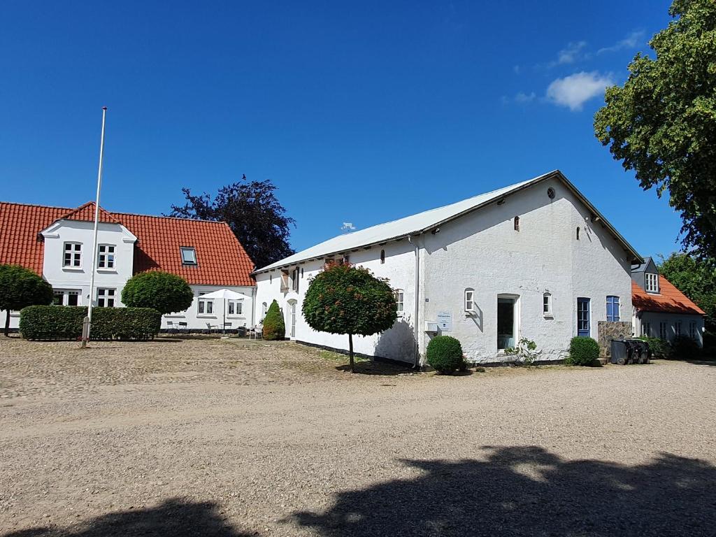 JelsPension Slotsgaarden jels的两栋房子的院子中的白色建筑