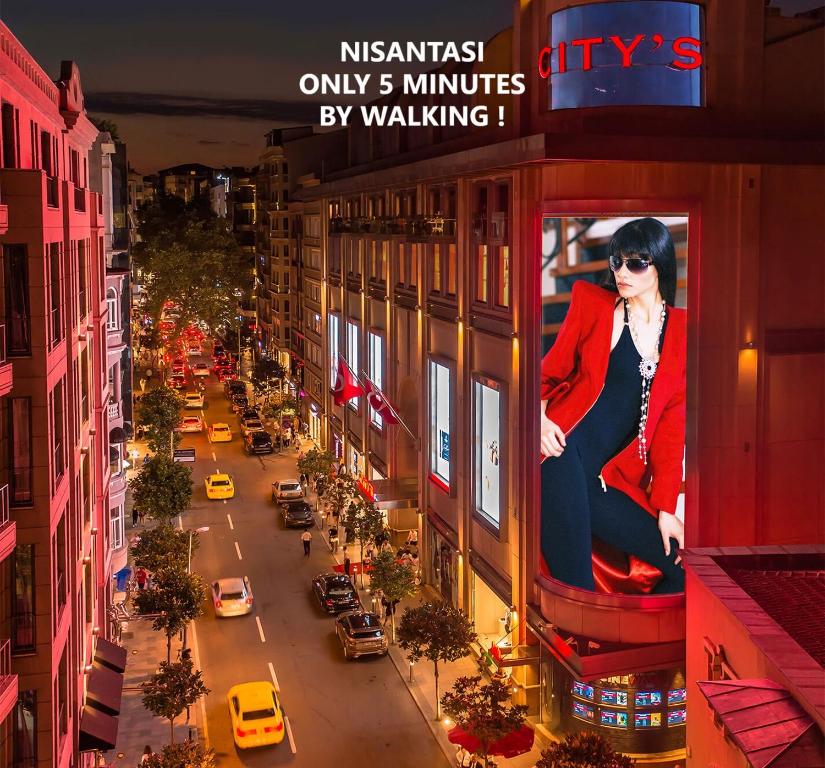 伊斯坦布尔TRYP By Wyndham Istanbul Sisli Hotel的建筑物边的女画像