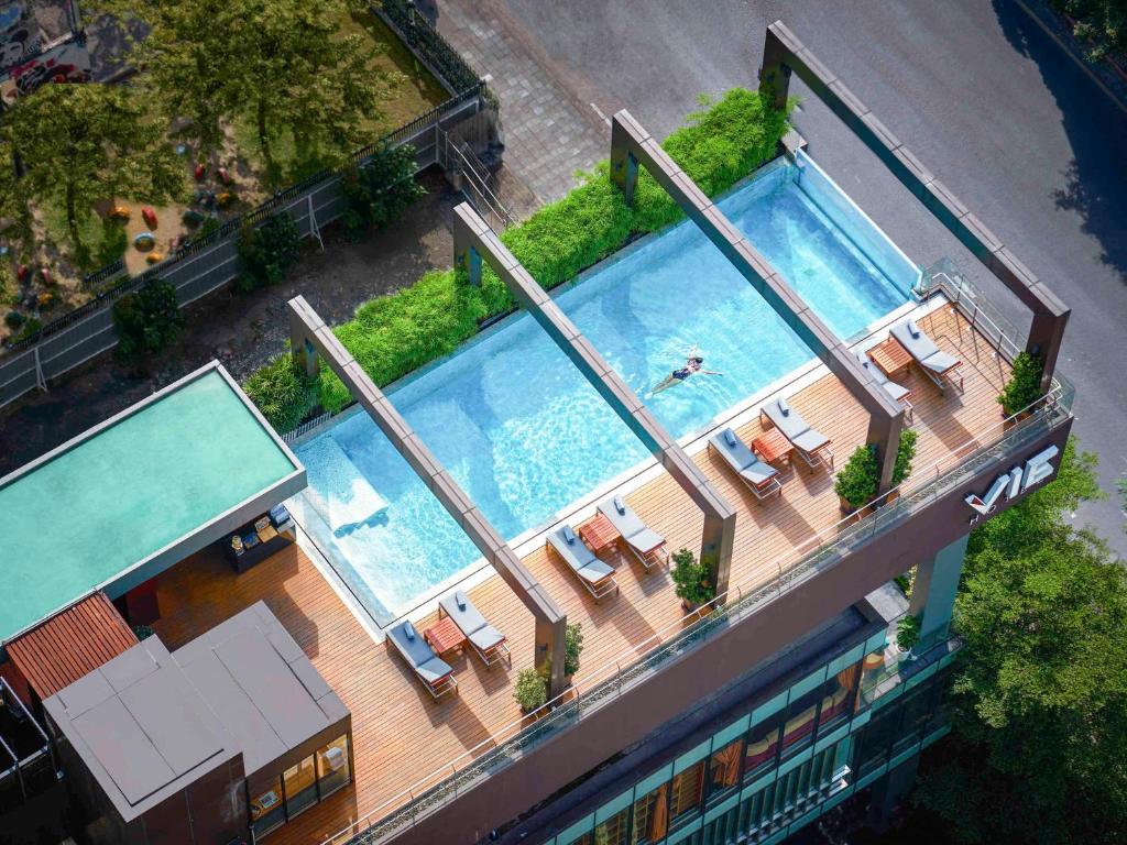 曼谷VIE Hotel Bangkok, MGallery的享有带躺椅的游泳池和游泳池的顶部景致