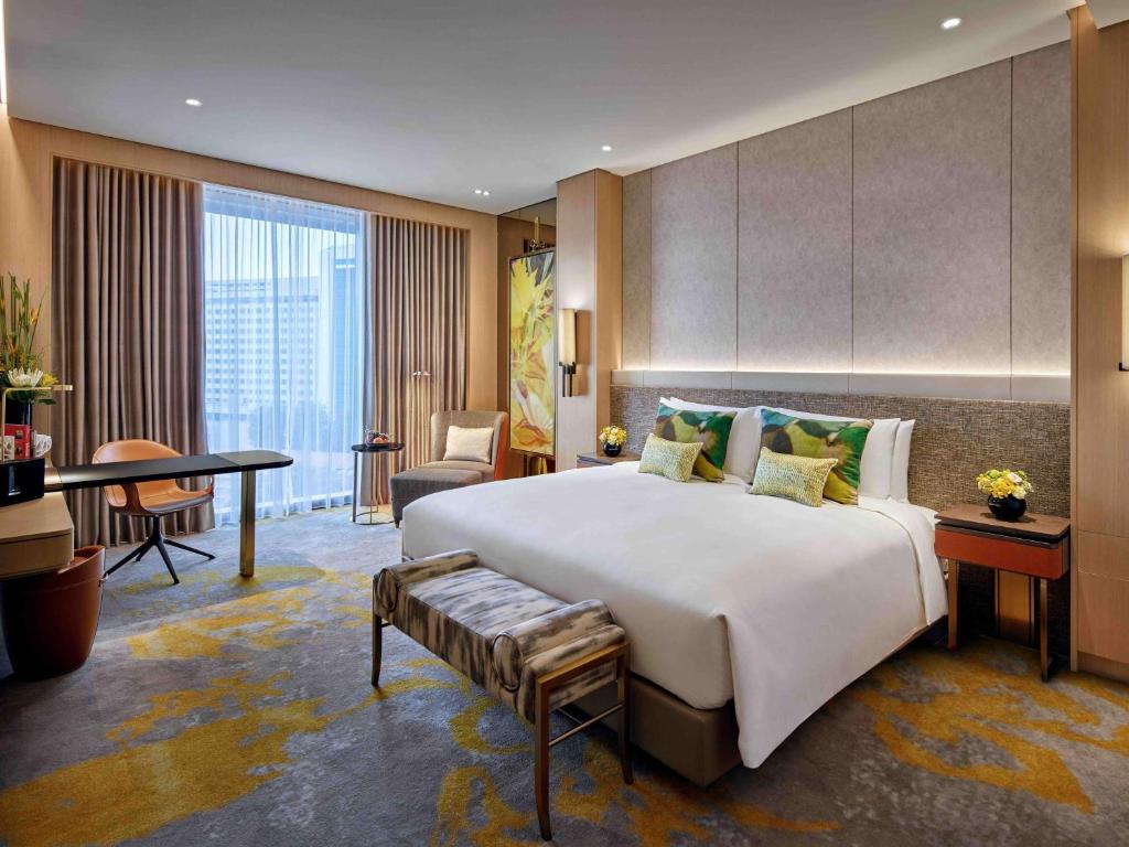 新加坡Sofitel Singapore City Centre的酒店客房设有一张大床和一张书桌。