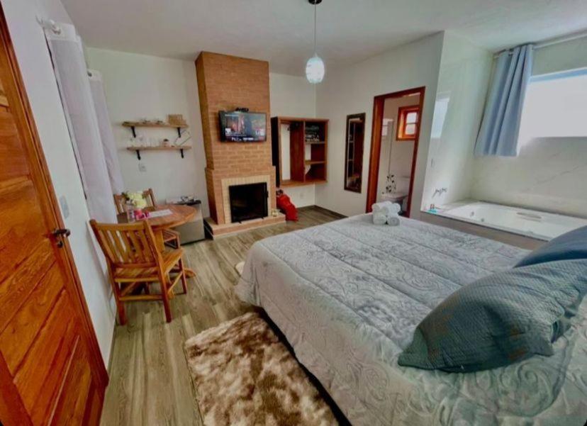 蒙特韦尔迪Refugio Victoria的一间卧室设有一张大床和一个壁炉