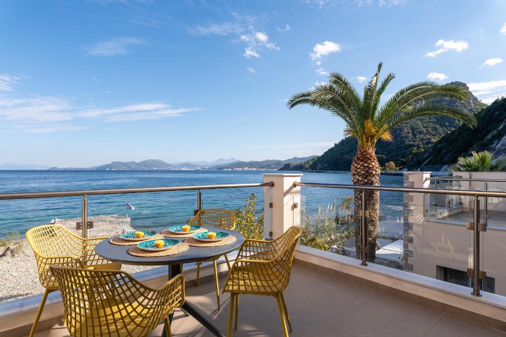 库卡里8MOONS Elegant Apartments的阳台配有桌椅,享有海景。
