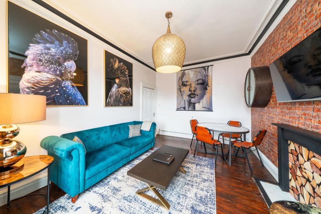 布莱尔高里Central Apartment - Industrial的客厅设有蓝色的沙发和壁炉