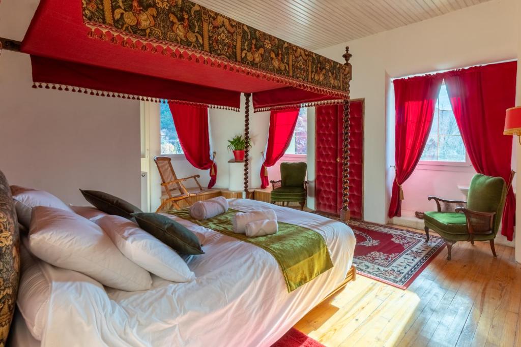 蒙特摩尔Château le Beylon - Chambres d'hôtes的一间卧室配有一张带红色窗帘的大床