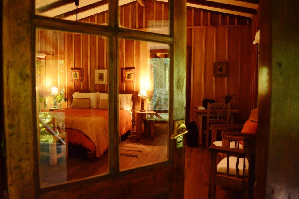 埃尔索韦维奥Margay - Reserva Natural y Lodge de Selva的一间卧室设有一张床和一个玻璃门
