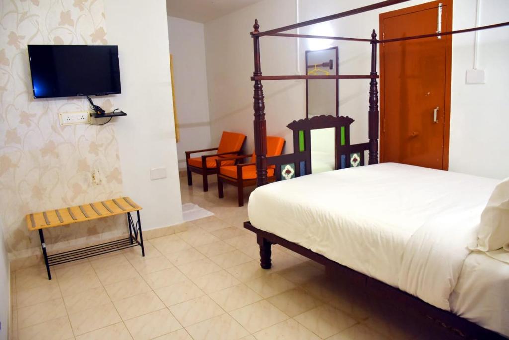 埃尔加德Vacation villa的一间卧室配有一张床、一台电视和椅子