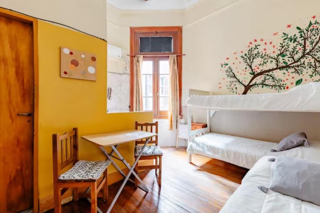 布宜诺斯艾利斯Dante y compañia的一间卧室配有一张床、一张桌子和一张桌子