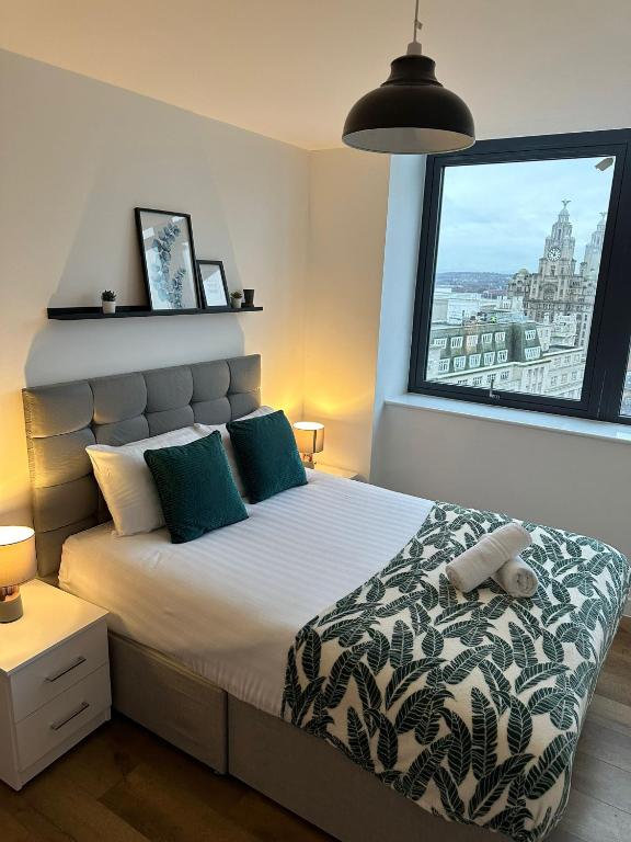 利物浦Stunning City View Apartment by Central Stay的一间卧室设有一张大床和大窗户