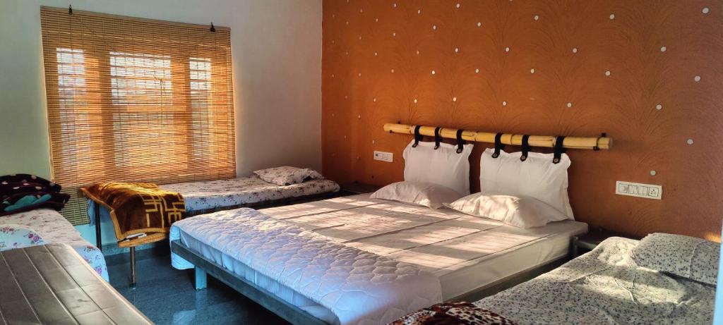 ChāndawāriLalera stay的一间卧室设有两张床和窗户。