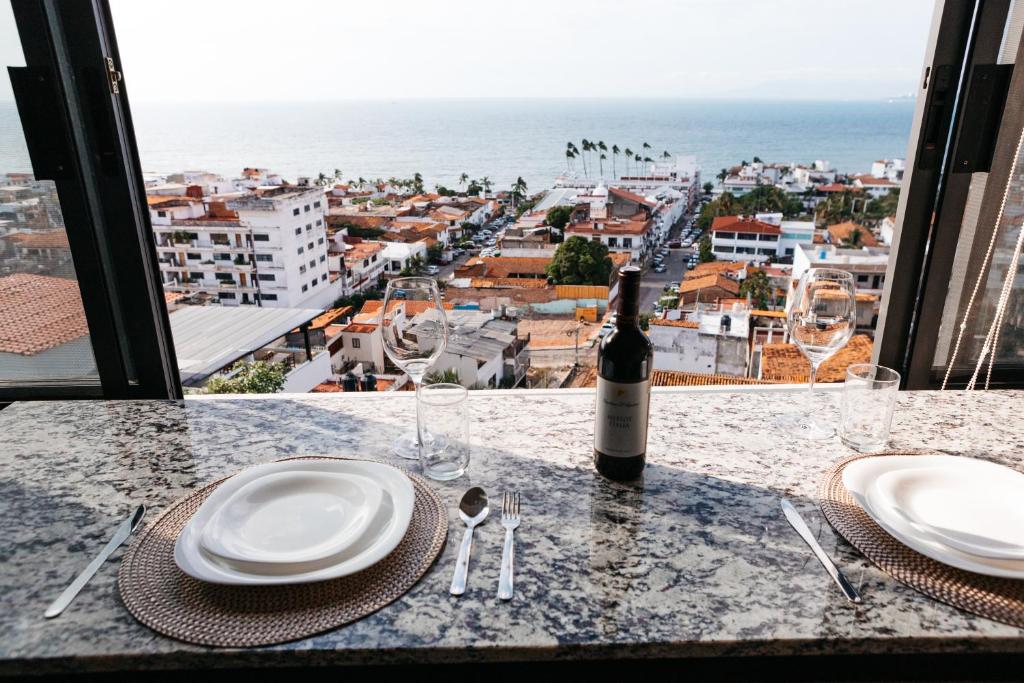 巴亚尔塔港Monyxbnb Hotel的一张桌子,上面放着一瓶葡萄酒,一张桌子还享有美景。