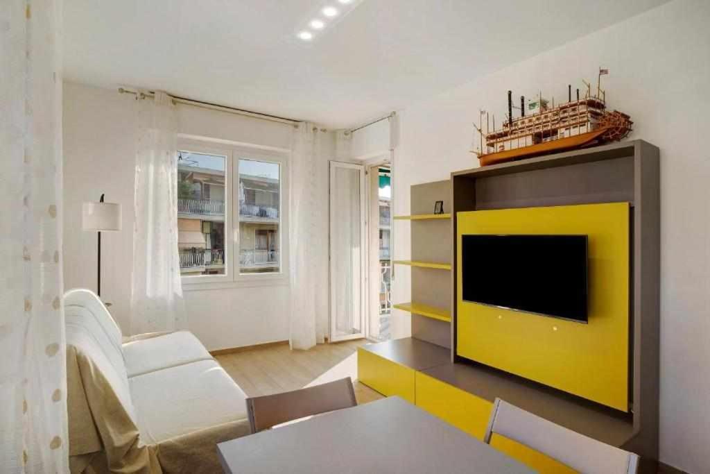 圣雷莫Ninfea apartments的一间带电视和黄色墙壁的客厅