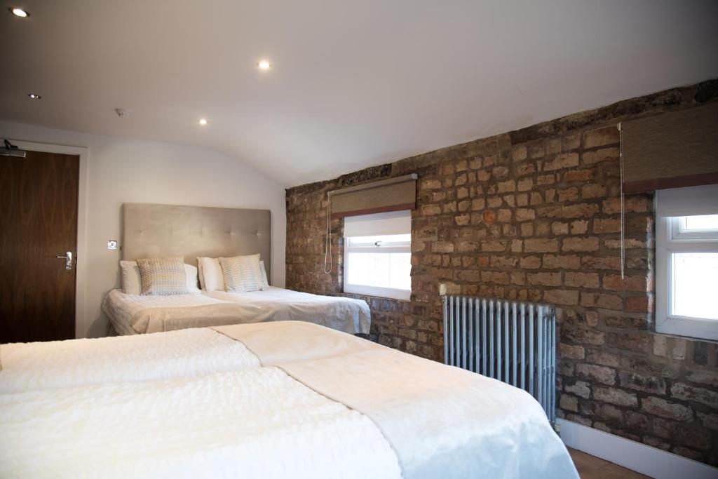 利物浦里士满德公寓的一间卧室设有两张床和砖墙