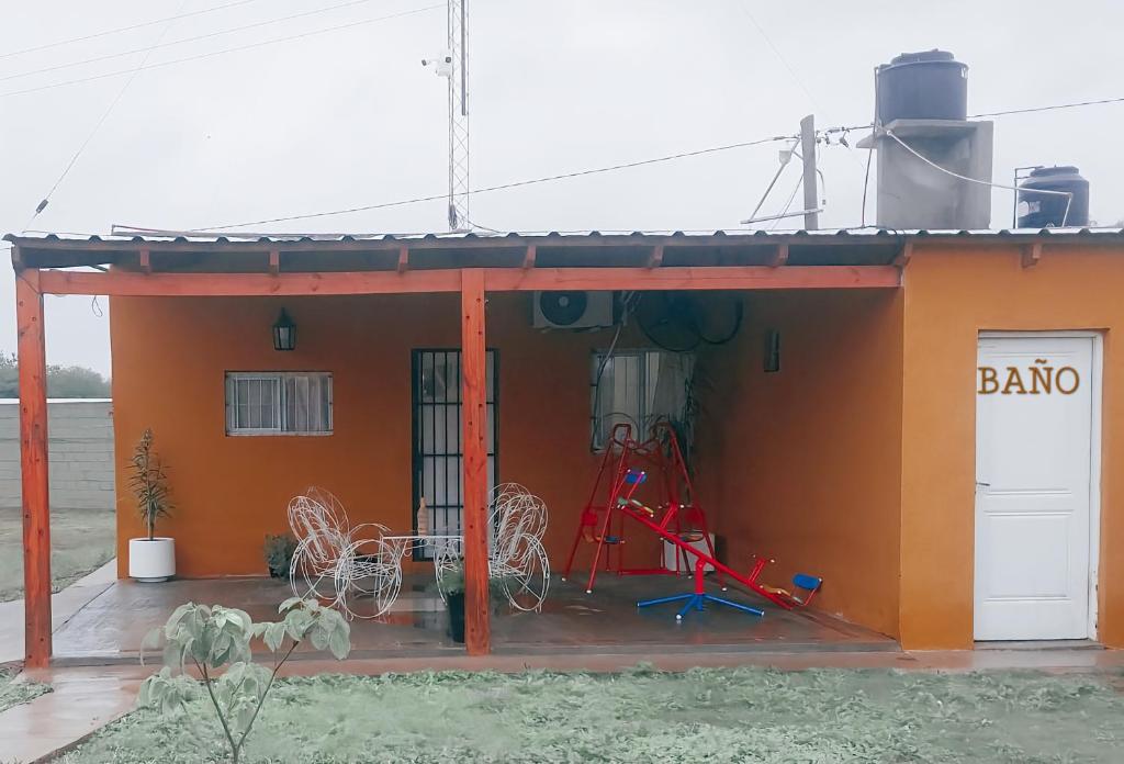 圣地亚哥-德尔埃斯特罗Casa de Campo Atenea的一座橙色的小建筑,外面有一辆自行车停放