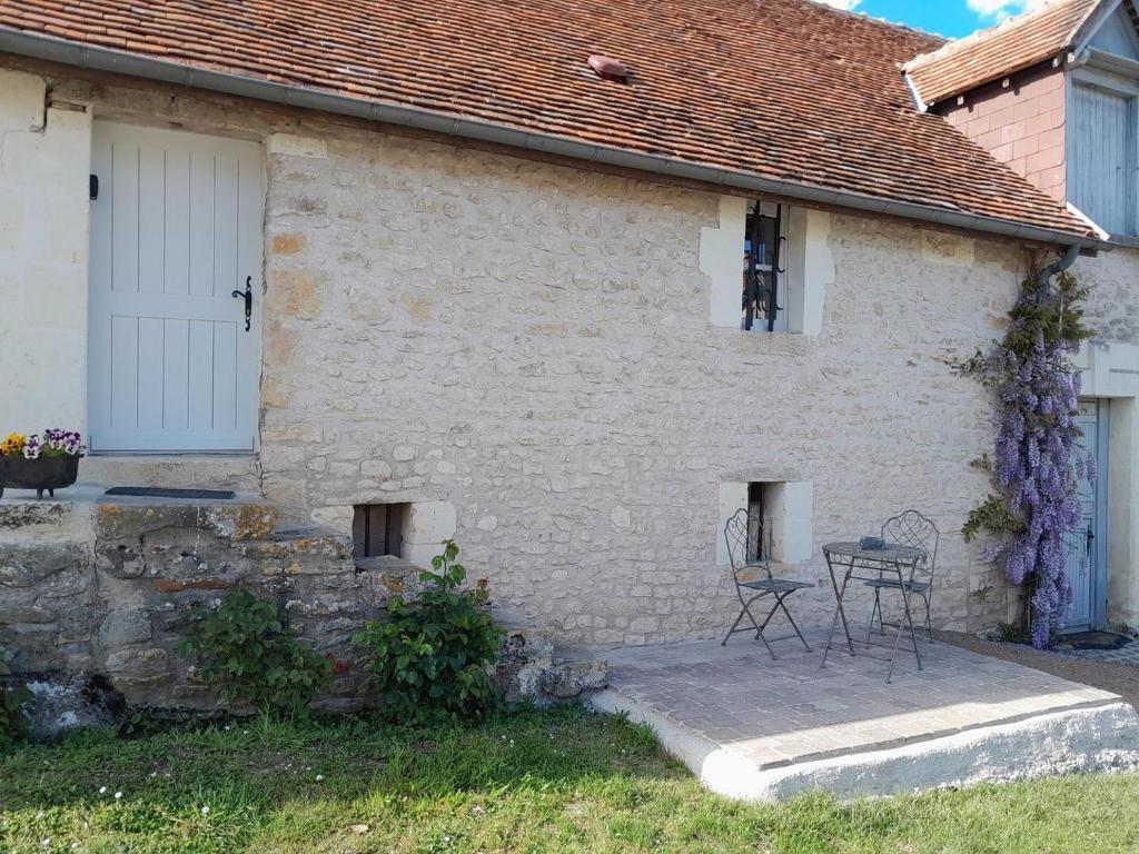 Chambourg-sur-IndreCharmante petite maison 2 personnes的白色砖屋,外面配有桌椅