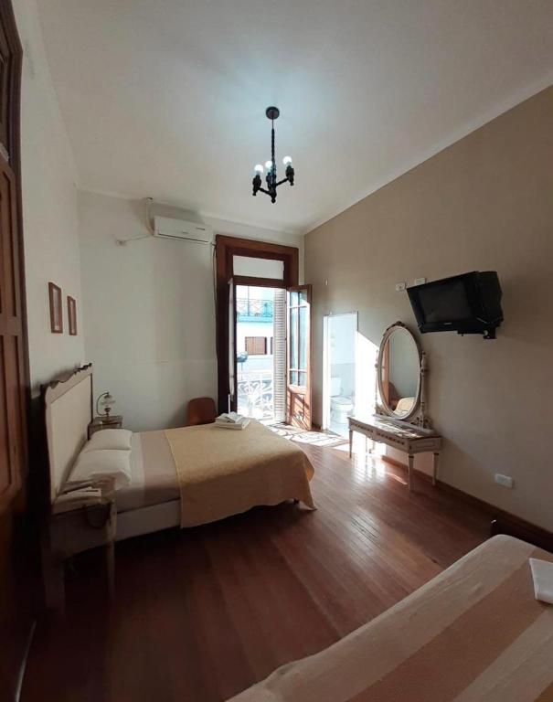 乌拉圭河畔康塞普西翁HOTEL LOURD MARY的一间卧室配有一张床、镜子和电视
