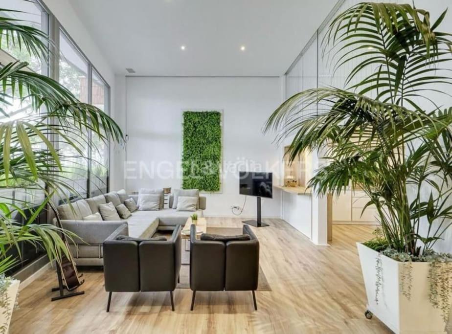 巴达洛纳apartamento exclusivo muy cerca ciudad Barcelona的带沙发和两棵棕榈树的客厅