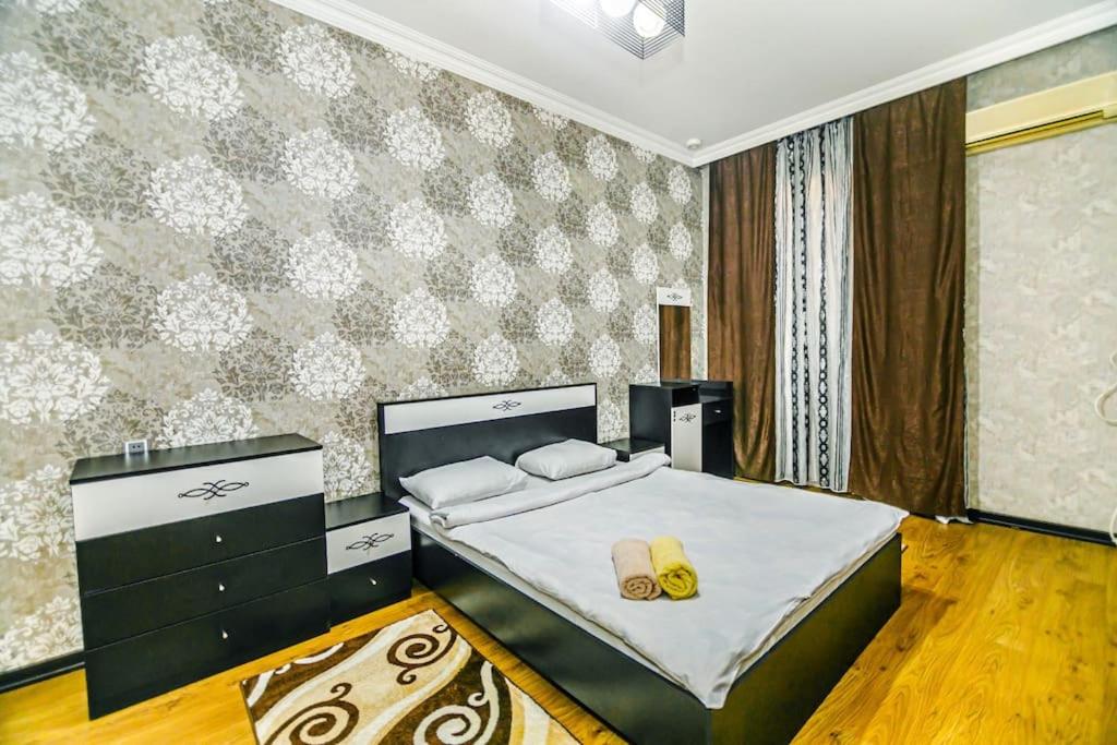 巴库Apartment Armani Lux的一间卧室配有一张床,并备有2个拖鞋