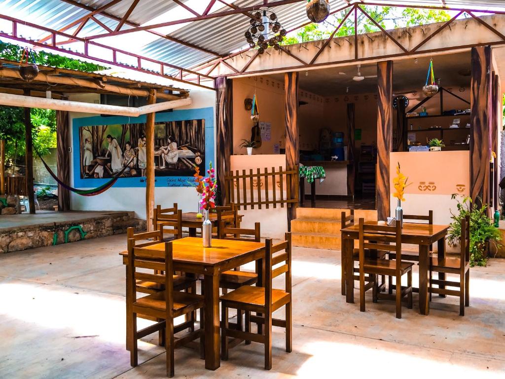 巴卡拉尔Yaxche Centro Hostal y Camping的餐厅前面设有木桌和椅子